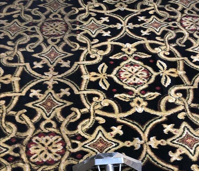 black area rug with gold and red design, left is dirty, right is clean